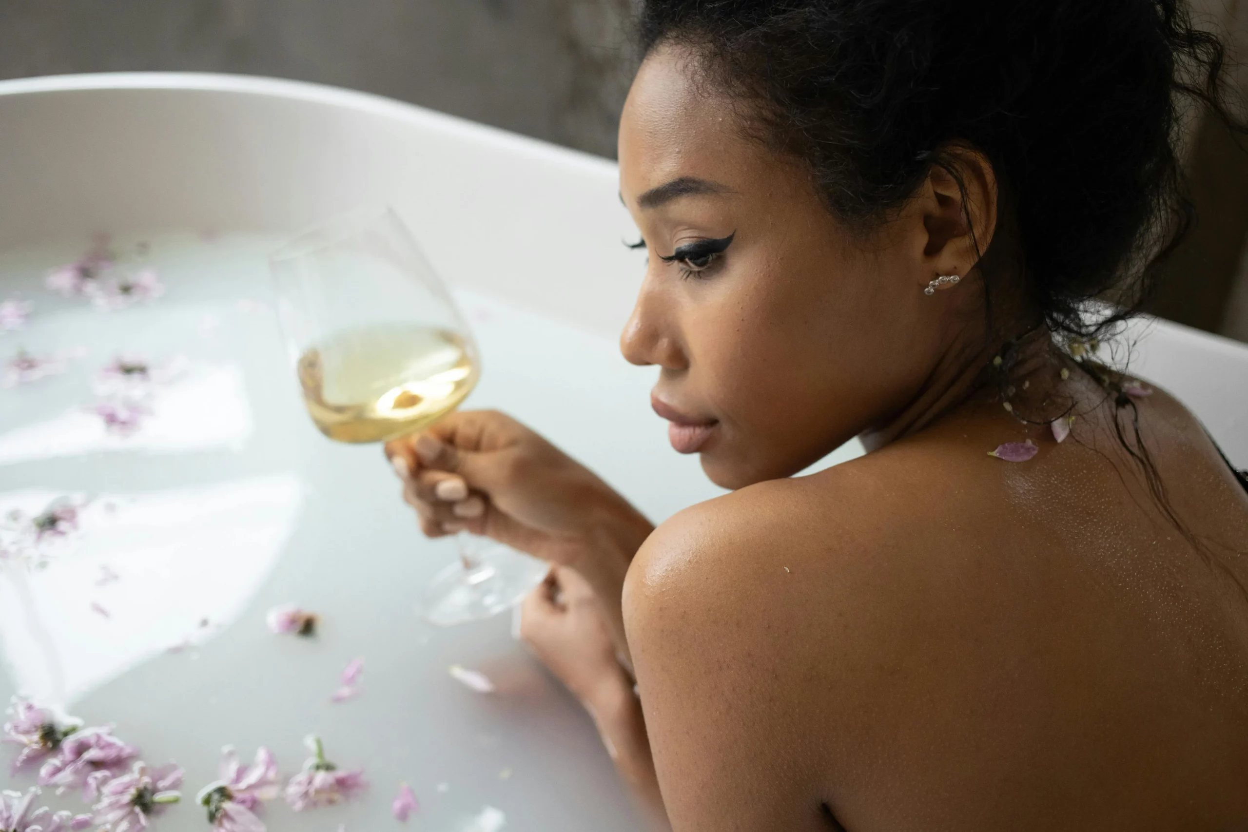 Femme dans baignoire avec verre de vin blanc